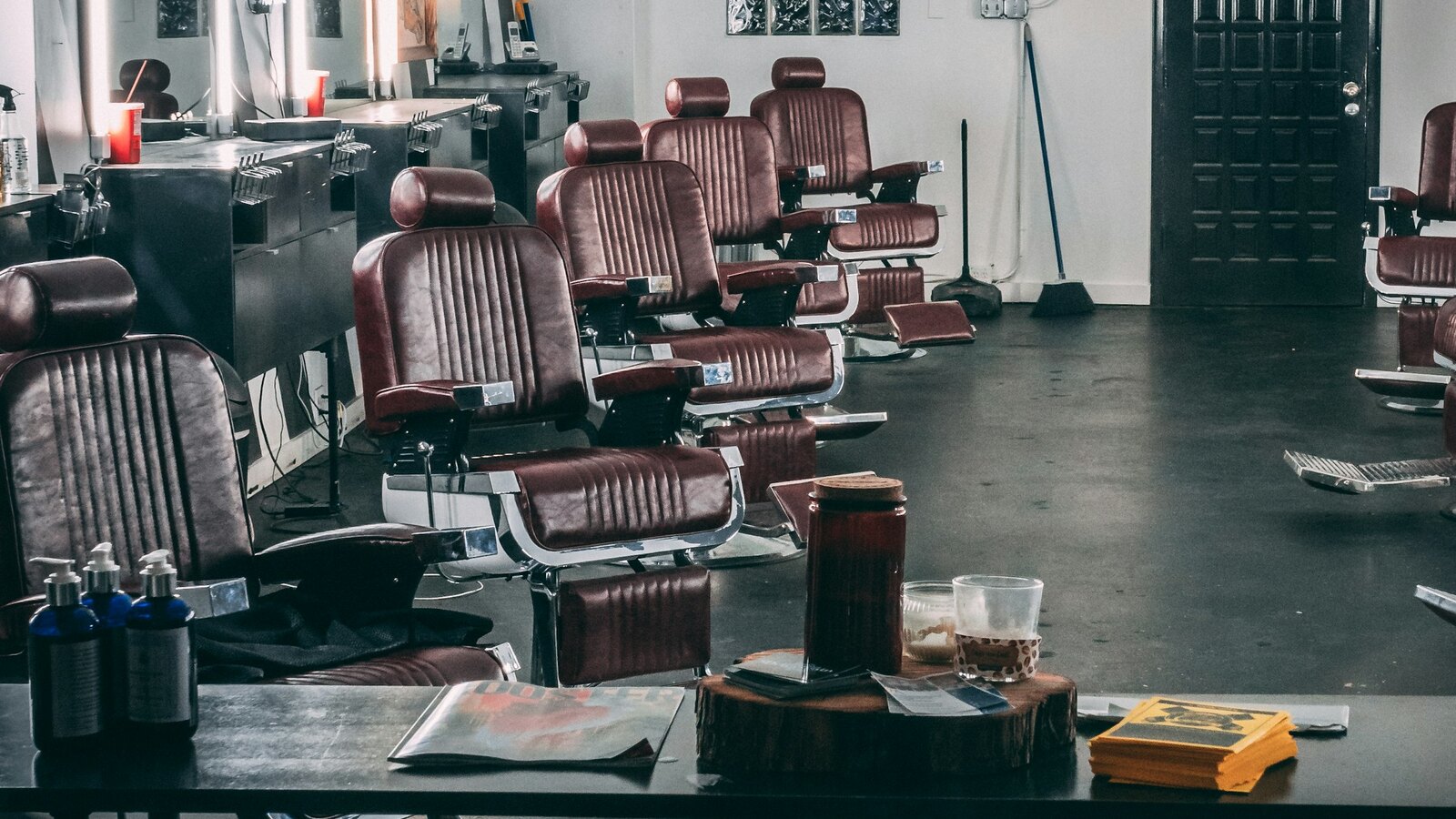 Moody Fade and Steel barbershop interior with dark wood and brass